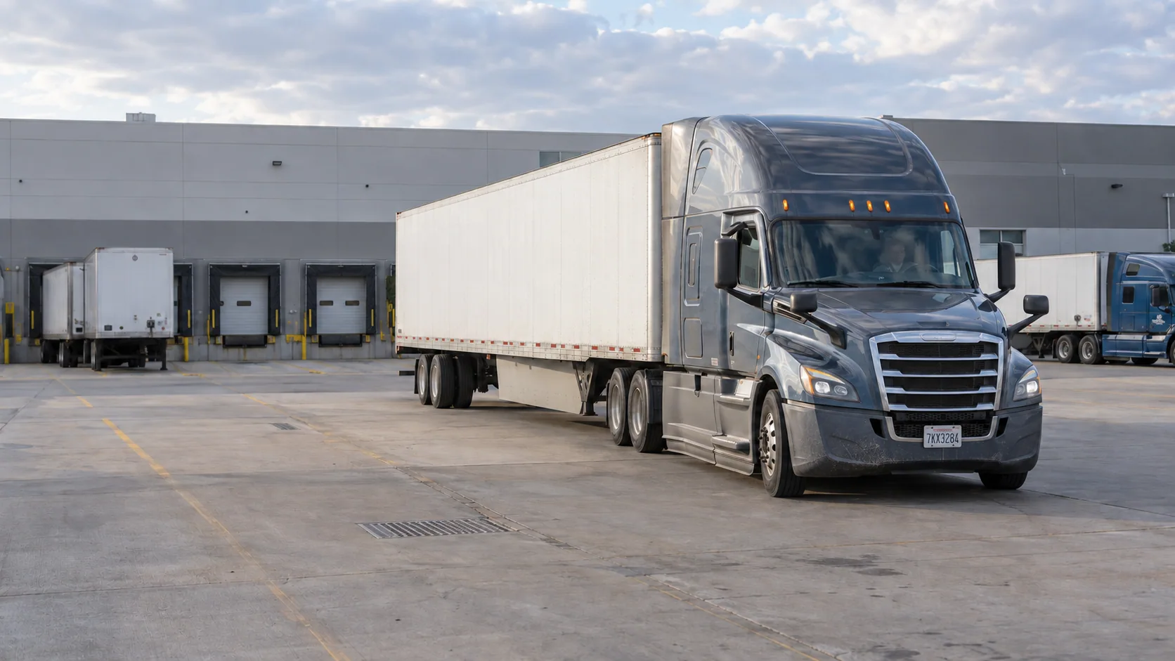 Illustrative Freightliner Cascadia with a dry-van trailer at a loading terminal